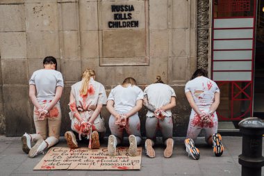 28.04.2022 Barselona, İspanya. Rusya 'nın evi. Ukraynalı aktivistlerin Ukrayna 'daki savaş sırasında kadınlara ve çocuklara tecavüz etmelerini protesto etmek. Kanlı ellerde kızlar şiddet kurbanlarını taklit ediyorlar.