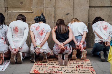 28.04.2022 Barselona, İspanya. Rusya 'nın evi. Ukraynalı aktivistlerin Ukrayna 'daki savaş sırasında kadınlara ve çocuklara tecavüz etmelerini protesto etmek. Kanlı ellerde kızlar şiddet kurbanlarını taklit ediyorlar.