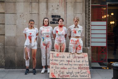 28.04.2022 Barselona, İspanya. Rusya 'nın evi. Ukraynalı aktivistlerin Ukrayna 'daki savaş sırasında kadınlara ve çocuklara tecavüz etmelerini protesto etmek. Kanlı ellerde kızlar şiddet kurbanlarını taklit ediyorlar.