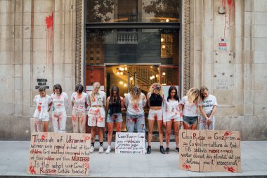 28.04.2022 Barselona, İspanya. Rusya 'nın evi. Ukraynalı aktivistlerin Ukrayna 'daki savaş sırasında kadınlara ve çocuklara tecavüz etmelerini protesto etmek. Kanlı ellerde kızlar şiddet kurbanlarını taklit ediyorlar.