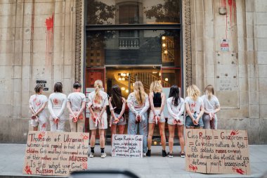 28.04.2022 Barselona, İspanya. Rusya 'nın evi. Ukraynalı aktivistlerin Ukrayna 'daki savaş sırasında kadınlara ve çocuklara tecavüz etmelerini protesto etmek. Kanlı ellerde kızlar şiddet kurbanlarını taklit ediyorlar.