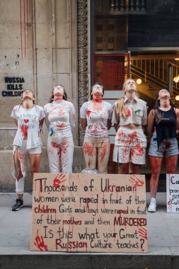 28.04.2022 Barselona, İspanya. Rusya 'nın evi. Ukraynalı aktivistlerin Ukrayna 'daki savaş sırasında kadınlara ve çocuklara tecavüz etmelerini protesto etmek. Kanlı ellerde kızlar şiddet kurbanlarını taklit ediyorlar.