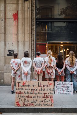 28.04.2022 Barselona, İspanya. Rusya 'nın evi. Ukraynalı aktivistlerin Ukrayna 'daki savaş sırasında kadınlara ve çocuklara tecavüz etmelerini protesto etmek. Kanlı ellerde kızlar şiddet kurbanlarını taklit ediyorlar.