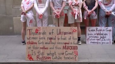 28.04.2022 Barselona, İspanya. Rusya 'nın evi. Ukraynalı aktivistlerin Ukrayna 'daki savaş sırasında kadınlara ve çocuklara tecavüz etmelerini protesto etmek. Kanlı ellerde kızlar şiddet kurbanlarını taklit ediyorlar.
