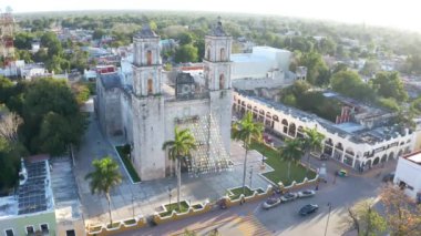 Valladolid Mexico 'daki Iglesia De San Servacio Katedrali' nin şehir meydanındaki hava görüntüleri. Akşam güneşi ışığı. sabit kamera bir yerde. Dekoratif bayraklar dalgalanıyor. Taksi trafiği