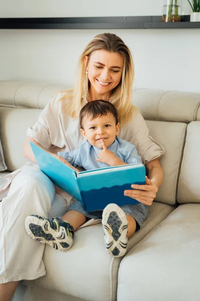 可爱的2岁男孩看着相机笑了 和孩子一起读书美丽的金发女人拿着书和儿子玩耍 放松与家人在一起的时间 抚养和教育 垂直方向 — 图库照片