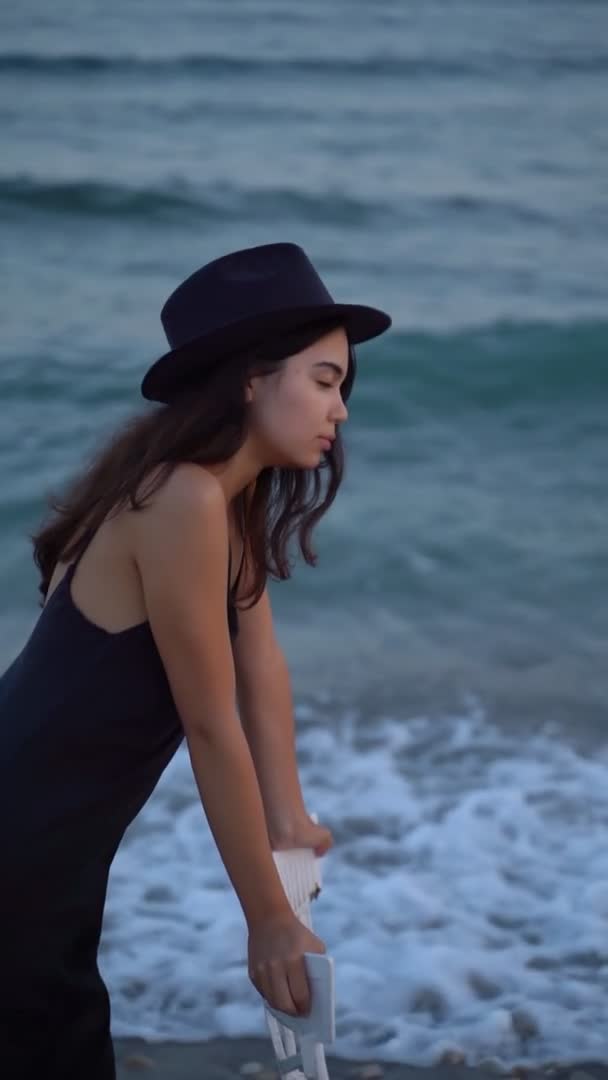 Beautiful Young Woman Black Dress Hat Hear Sea Vertical Slow — Video