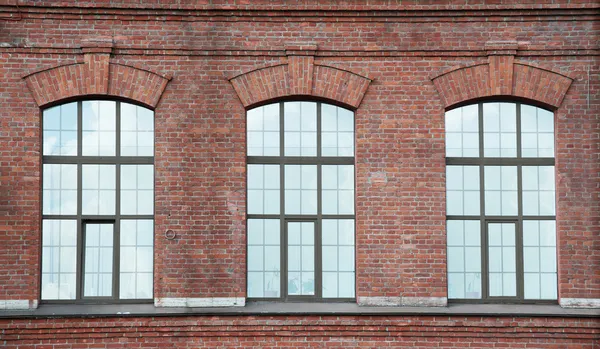 Drei Fenster auf einer roten Ziegelwand — Stockfoto