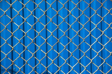 Güneşli mavi çit arka plan paslı mesh.