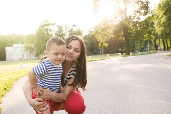 Happy family outdoor, boy running out of his mother — Stock Photo, Image