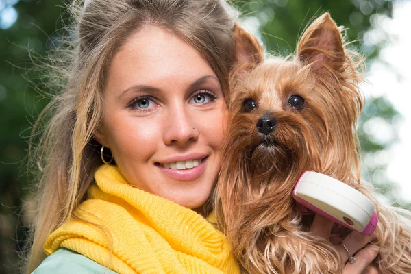 Lachende blonde met haar kleine hond. — Stockfoto