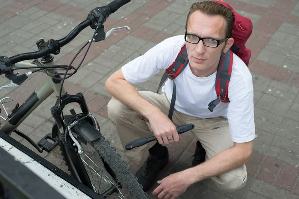 Человек чинит велосипед на улице — стоковое фото