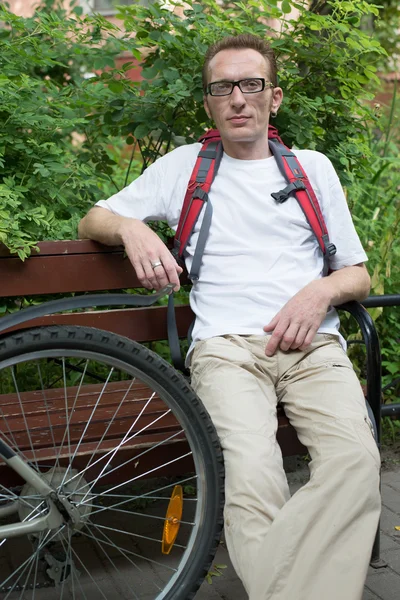Homme avec repose-vélo sur le banc — Photo