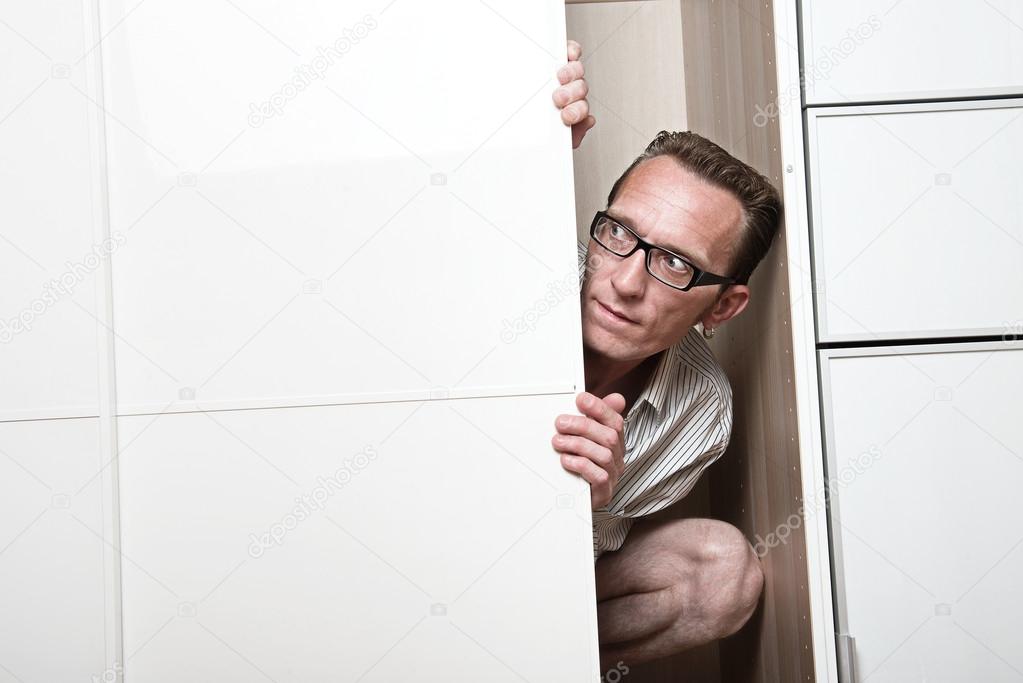 Concerned man look out white wardrobe