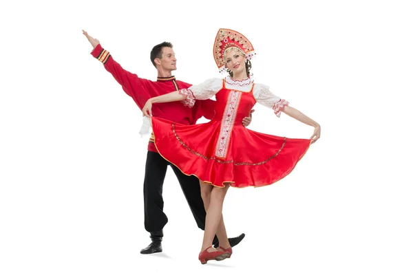 Casal de dançarinos em trajes tradicionais russos, menina em sarafan vermelho e kokoshnik, menino em calças pretas e camisa vermelha — Fotografia de Stock