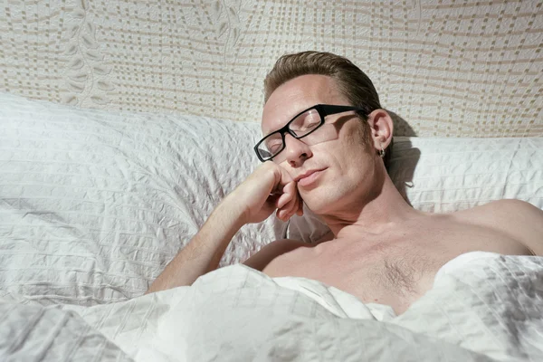 Tired naked handsome mid-ages man slept even not to pull off the eyeglasses. — Stock Photo, Image