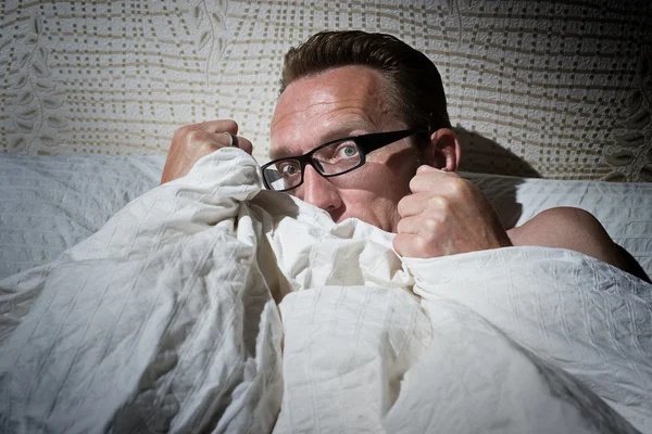 Frightened naked man under the blanket — Stock Photo, Image