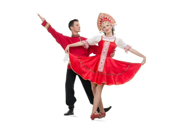 Pareja de bailarines en trajes tradicionales rusos, chica en sarafán rojo y kokoshnik, chico en pantalones negros y camisa roja Imagen de archivo
