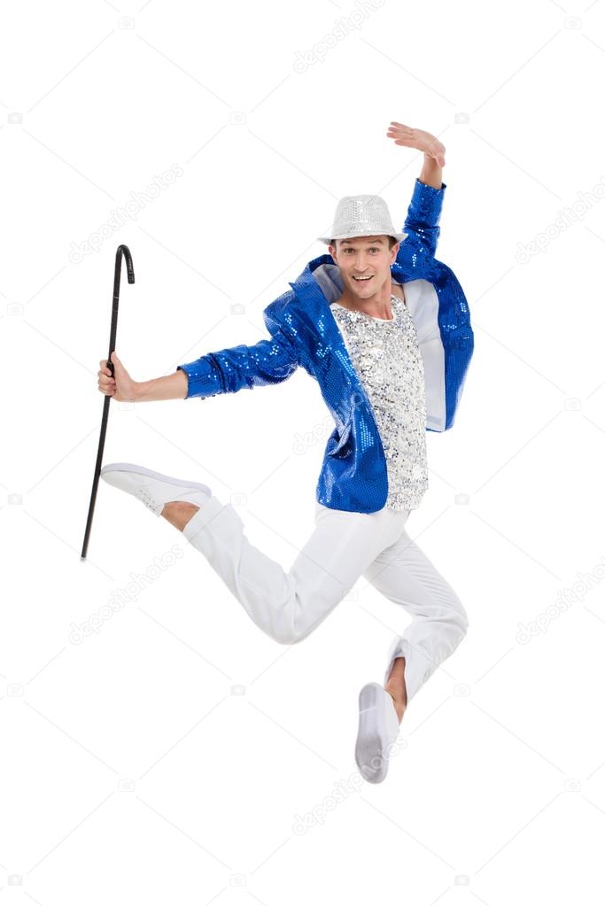 Man dancer in the blue sparkle suit and white trousers jumping.