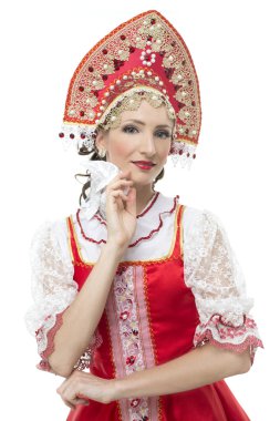 Smile coquettish young woman portrait  in russian traditional costume --  red sarafan and kokoshnik. clipart
