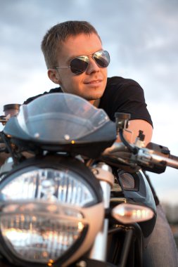 bisikletle yakın göl günbatımı romantik portre yakışıklı motorcu erkek güneş gözlüğü oturur