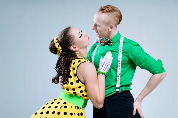 Retrato lindo casal dançarino engraçado vestido de boogie-woogie rock 'n' roll pin up estilo posando juntos em estúdio . — Fotografia de Stock