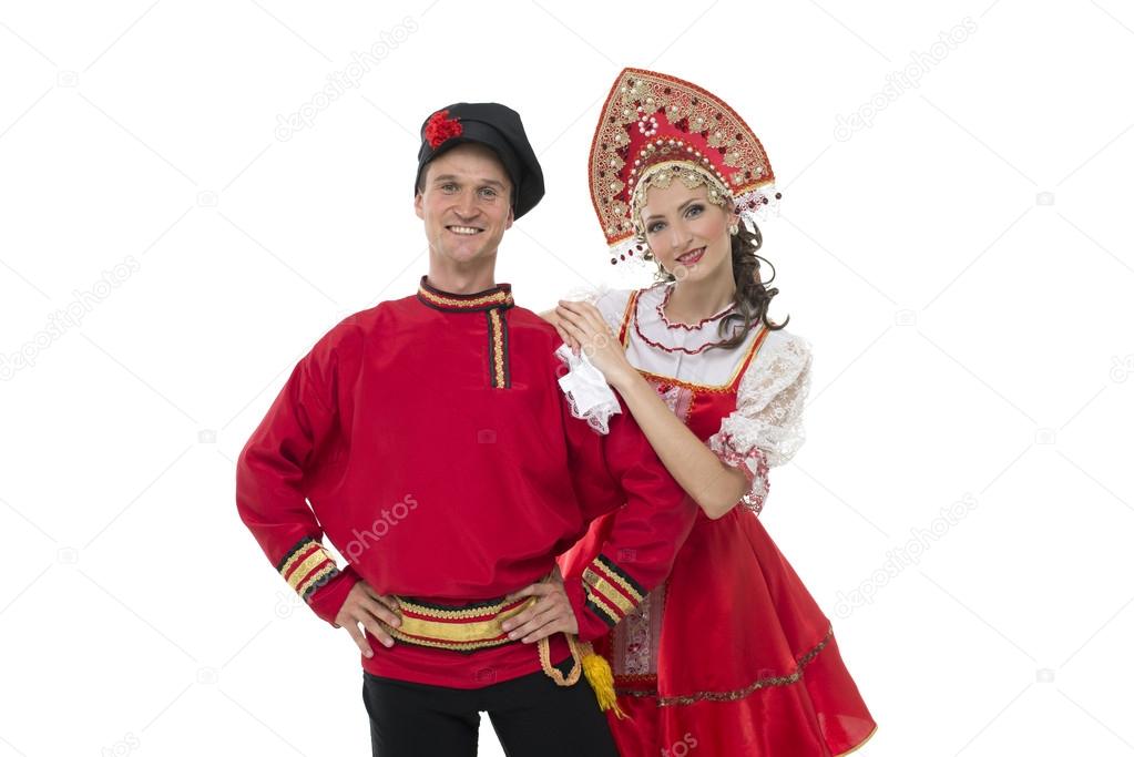 Portrait of young man and woman looking into the camera in russian traditional costumes
