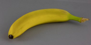 Gri arka planda sarı muz. Taze olgun meyve..