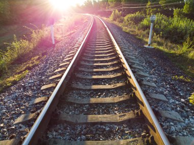 Railroad tracks sparkle in the bright morning sunrise