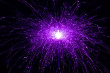 Sparkler, siyah arka planda mor kıvılcımlar. Kıvılcımların, tatil ışıklarının soyut fotoğrafı.