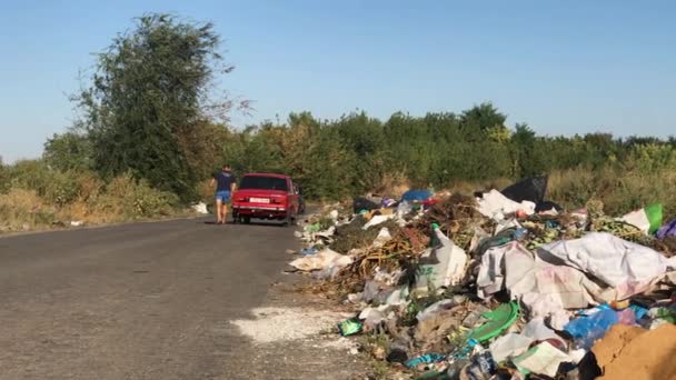 Auta zastavují přímo na kraji silnice, aby vysypali odpadky na spontánní skládku. — Stock video