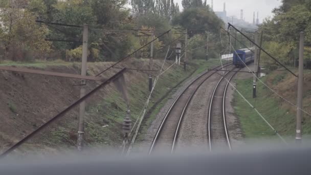 Камера с моста снимает железнодорожные пути. На поворот уезжает последняя машина.. — стоковое видео