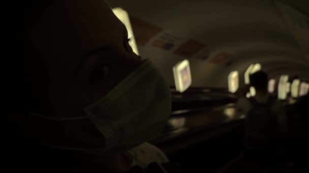 Tıbbi maskeli bir kız, asansörde karanlık bir tünele giriyor. — Stok video