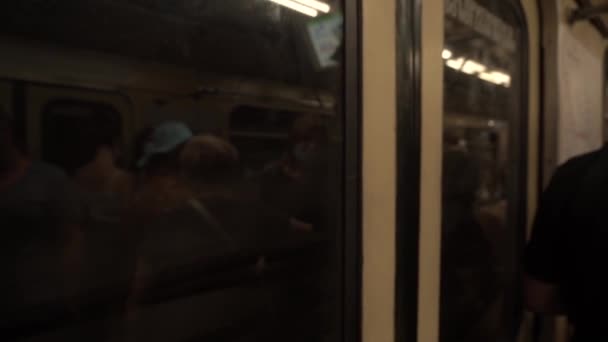 Un vagone della metropolitana parte da una stazione della metropolitana a tunnel buio con persone in attesa — Video Stock
