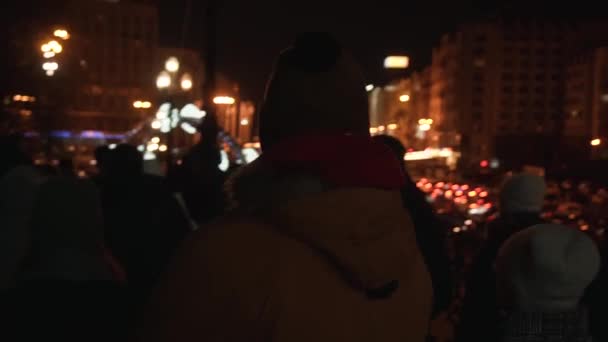 Ein Mann in gelber Jacke spaziert im neuen Jahr nachts durch die Innenstadt — Stockvideo