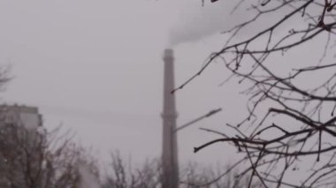 Bokeh chimneys with smoke near the park and residential buildings