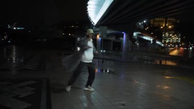Kız gece sokakta dans ediyor, ev dansı tarzı, şehir merkezinde.