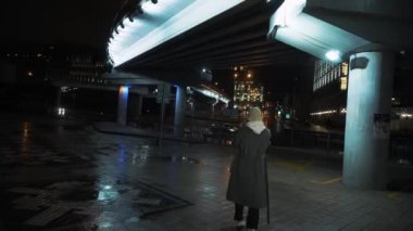 Young woman waiting for someone in city, using smart watch, checking time, reading message.