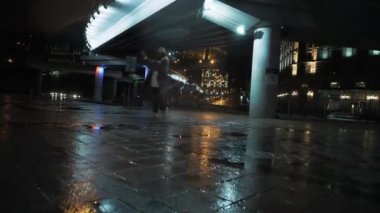 Kız gece sokakta dans ediyor, ev dansı tarzı, şehir merkezinde.