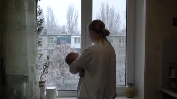 Yalnız anne, kışın karın altında emziren bebeğini sakinleştirmeye yardım ediyor. — Stok video