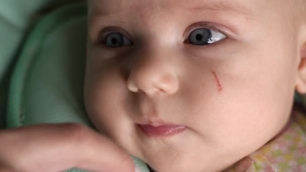 Close-up of a childs face. Mom touches her cheek with her finger — Stock Video