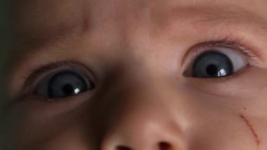Bir bebeğin mavi gözlerine yakın çekim yap. Kameraya bakıyor. Can sıkıntısını seğiriyor