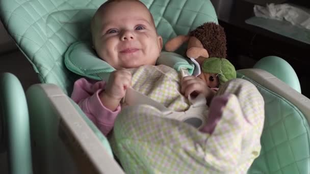 Feliz, bebê alegre olha mãe e sorri cozinha assento infantil. Dimples. Drooling — Vídeo de Stock