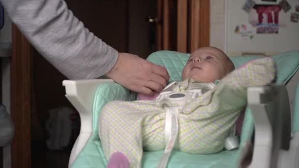 Omtänksam mor kontrollerar lilla barnet med handen, vidrör hals, näsa, händer, fingrar — Stockvideo
