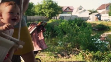 Salıncakta eğlenen gülümseyen beyaz bir çocuğun portresi. yavaş çekim.