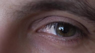 Yakın plan. İnsan gözü. Göz kırpıyor, kameraya bakıyor, gözlerini kısıyor.