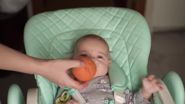 A baby, with blue eyes, is breastfed, they give orange food — Vídeo de Stock