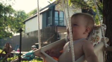 Ağır çekim. Mutlu baba ve çocuk birbirine bakar, güler. Swing 'teki kız babasıyla kırsal kesimdeki Aile Evi' nde eğleniyor. Tasasız Çocukluk Anıları Konsepti. Ağaç, gülümseme, neşe, günbatımı
