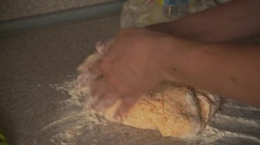 the cook carefully kneads the sticky dough with the pumpkin. fingers stick, sprinkle flour on top. a large piece of dough will be divided into smaller pieces