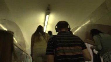 KIEV, UKRAINE - 15 Temmuz 2021: Kalabalık bölünmüş insanlar, maskesiz, sosyal mesafeli metro istasyonlarına gidiyorlar. Büyük avizeleri, korkulukları, kemerleri olan güzel metro istasyonu.